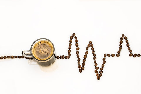 cup of coffee with heart rate depicted with coffee beans next to it