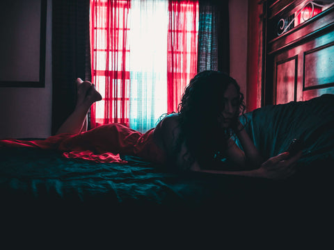 woman using phone in bed