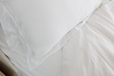 close up of ethical bedding bed sheets on bed in white