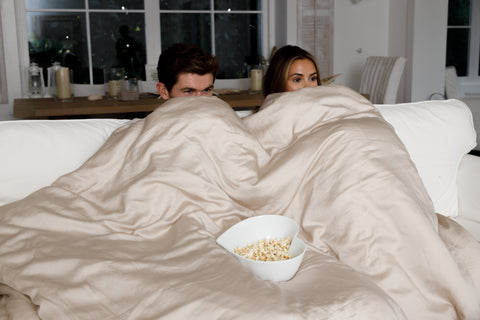 couple on sofa wrapped in eucalyptus silk duvet set