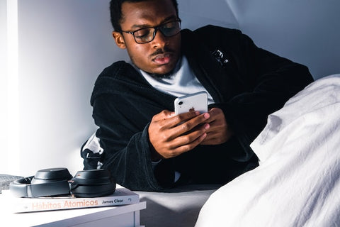 man using his phone in bed