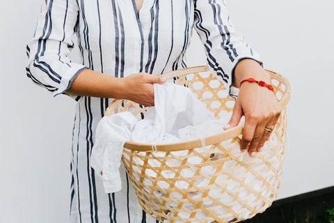 lady holding laundry basket with sheet inside it